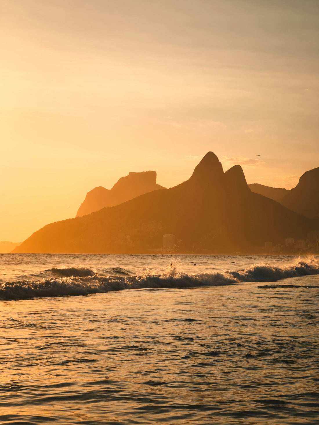 Golden sunset over the sea with Dois Irmãos mountain in Rio de Janeiro